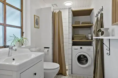 a bathroom with a sink and a washing machine at LF14163-Roslev-Kybehuse-3 in Roslev