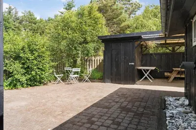 a patio with chairs and a table and a fence at LF10213-Thyholm-Haervej-9-B in Thyholm