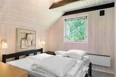 a bedroom with a bed with white sheets and a window at LF12017-Spottrup-Albaekparken-144 in Spottrup
