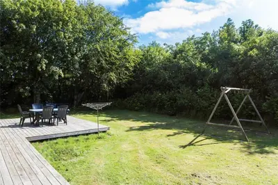 a patio with a table and chairs in the grass at LF12017-Spottrup-Albaekparken-144 in Spottrup