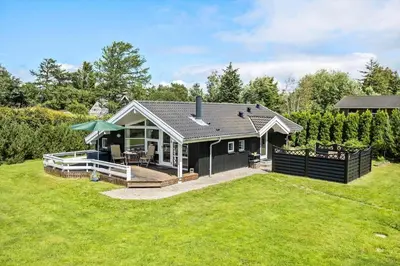 a small black house with a patio and a yard at LF16182-Logstor-Minnasvej-50 in Løgstør