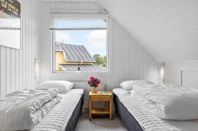 two beds in a room with a window at LF14127-Roslev-Kybehuse-127 in Roslev