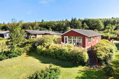 a red house on a hill with a yard at LF11171-Struer-Klintevej-14 in Struer
