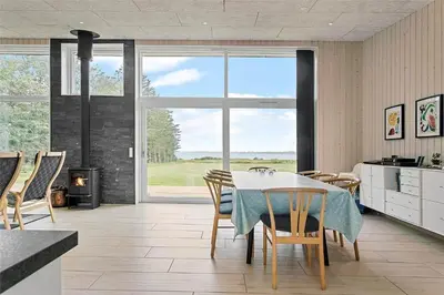 a kitchen with a table and chairs and a fireplace at LF14137-Spottrup-Fjordvej-39 in Spottrup