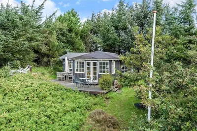 a cottage in the middle of a garden with a deck at LF11974-Struer-Havstokken-15A in Struer