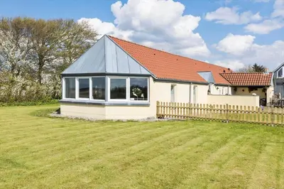 a small white house with a fence and a yard at LF14041-Roslev-Fur-Landevej-98 in Roslev