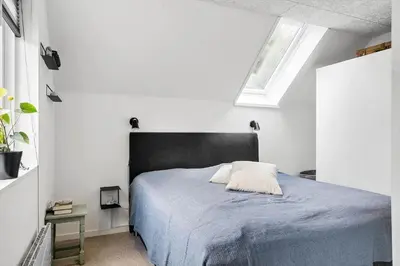 a bedroom with a bed with a black headboard and a window at LF11122-Struer-Plantagevej-22 in Struer