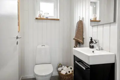 a bathroom with a white toilet and a sink at LF10058-Thyholm-Fyrrevej-17 in Thyholm
