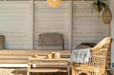 a wicker chair and a table on a patio at LF10058-Thyholm-Fyrrevej-17 in Thyholm