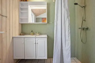 a bathroom with a white sink and a shower at LF13172-Nykobing-M-Strandvaenget-76 in Ejerslev