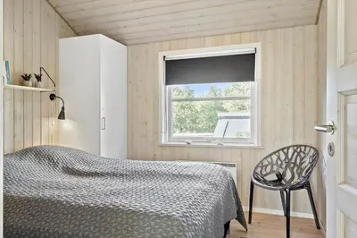 a bedroom with a bed and a window at LF10210-Thyholm-Skovstien-10 in Thyholm