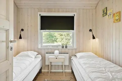 a small bedroom with two beds and a window at LF10210-Thyholm-Skovstien-10 in Thyholm