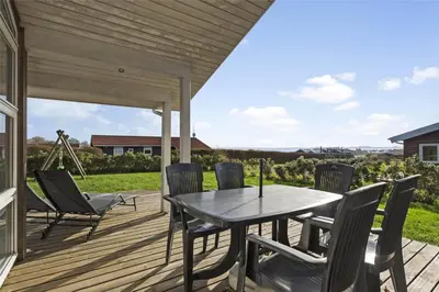 a patio with a table and chairs on a deck at LF884-Snedsted-Kongens-Borer-2 in Snedsted