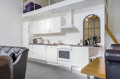 a white kitchen with white cabinets and a couch at LF14211-Roslev-Vile-Vestergardvej-34-Lejl-A-tv in Roslev