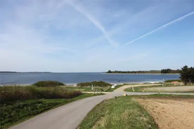 a dirt road next to a beach with the ocean at LF14211-Roslev-Vile-Vestergardvej-34-Lejl-A-tv in Roslev
