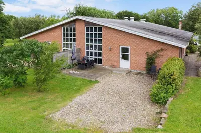 a brick building with a table and chairs in a yard at LF14211-Roslev-Vile-Vestergardvej-34-Lejl-A-tv in Roslev
