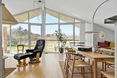 a living room with a dining room table and chairs at LF10229-Thyholm-Skovstjernevej-9 in Thyholm