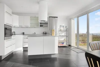 a kitchen with white cabinets and a large window at LF10214-Thyholm-Havnefronten-14 in Thyholm