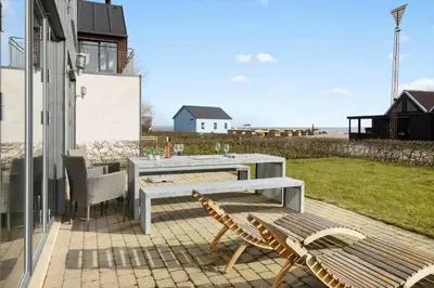a patio with a bench and a table and chairs at LF10214-Thyholm-Havnefronten-14 in Thyholm