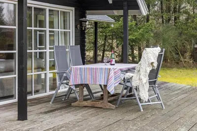 a table and two chairs on a porch with a table at LF10307-Hurup-Thy-Traelobervej-7 in Sønder Ydby