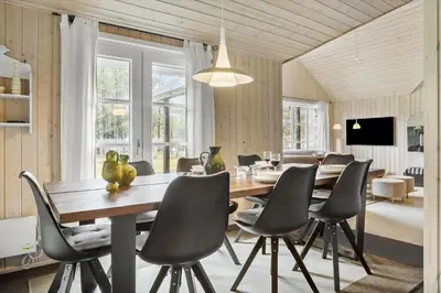 a dining room with a large wooden table and chairs at LF10307-Hurup-Thy-Traelobervej-7 in Sønder Ydby