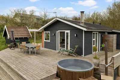 a backyard with a hot tub on a wooden deck at LF11116-Struer-Skovdammen-1 in Struer