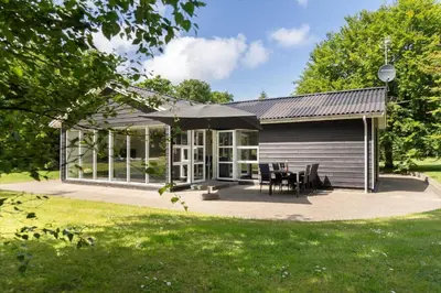 a house with a patio and an umbrella at LF10302-Hurup-Thy-Skibstedsvej-22-B in Sønder Ydby