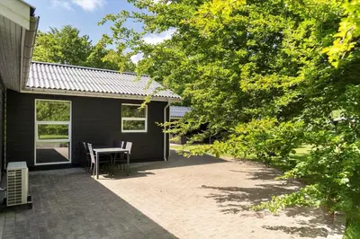 a patio with a table and chairs next to a house at LF10302-Hurup-Thy-Skibstedsvej-22-B in Sønder Ydby