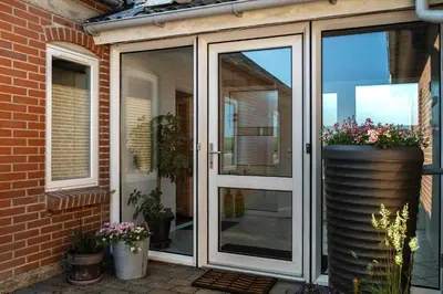 a sliding glass door on a house with flowers at LF10301-Hurup-Thy-Sindrupvej-1-B in Sindrup