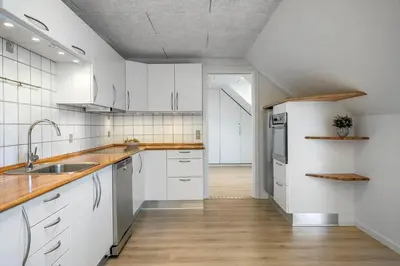 a kitchen with white cabinets and wooden floors and a sink at LF10301-Hurup-Thy-Sindrupvej-1-B in Sindrup