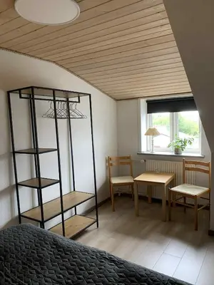 a bedroom with a bed and a table and chairs at Købmandsgården i Blære in Års