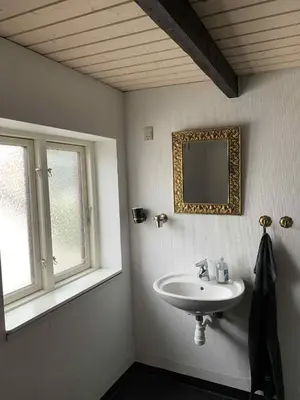 a bathroom with a sink and a mirror at Købmandsgården i Blære in Års