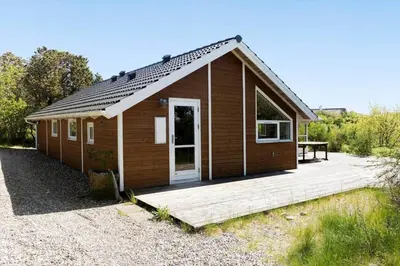 a small wooden cabin with a wooden deck at LF21631-Spottrup-Vibevej-3 in Spottrup