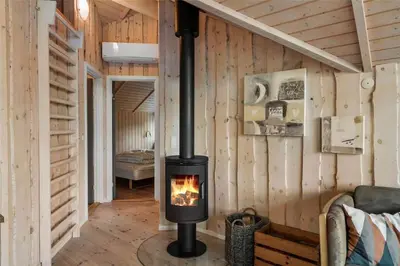 a fireplace in a room with wooden walls at LF21631-Spottrup-Vibevej-3 in Spottrup