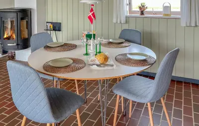 a dining room table with chairs and a fireplace at Beautiful Home In Pandrup With Wifi in Pandrup