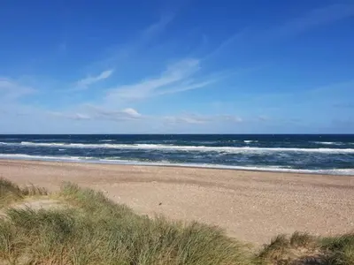 an empty beach with the ocean in the background at 6 person holiday home in Thisted in Thisted