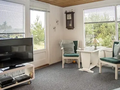 a living room with a television and a desk and chairs at 6 person holiday home in Thisted in Thisted