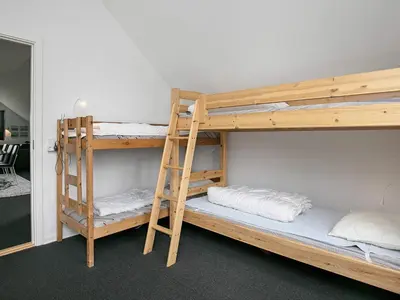 two bunk beds in a room with a ladder at 10 person holiday home in Ranum in Ranum