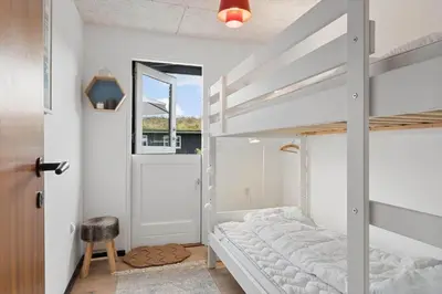 a bedroom with a bunk bed with a ladder at BL1116-Blokhus-Bloksbjerg-24 in Blokhus