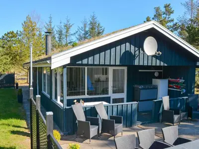 a blue shipping container house with chairs and a grill at 6 person holiday home in Blokhus