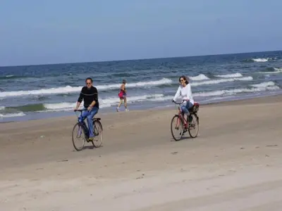 two people riding bikes on the beach at 6 person holiday home in Blokhus