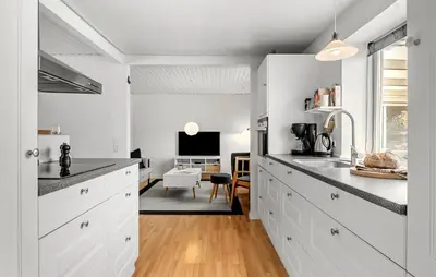 a kitchen with white cabinets and a living room at Pet Friendly Home In Farsø With House A Panoramic View in Farsø