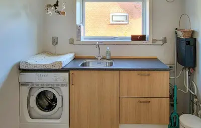 a kitchen with a sink and a washing machine at Lovely Home In Karby With Wifi in Karby