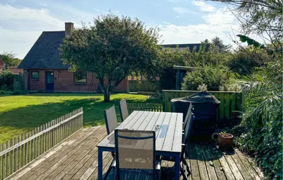 a table and chairs on a deck in a backyard at Lovely Home In Karby With Wifi in Karby