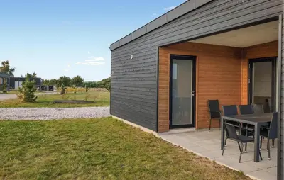 a patio with a table and chairs next to a building at 3 Bedroom Nice Home In Løgstrup in Løgstrup