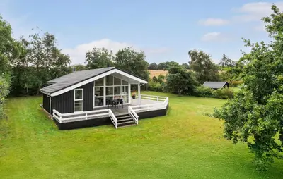 a small cabin with a porch on a grass field at Nice Home In Fjerritslev With Sauna in Fjerritslev
