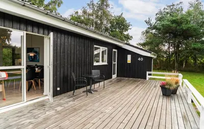a wooden deck with a table and chairs on a house at Nice Home In Fjerritslev With Sauna in Fjerritslev