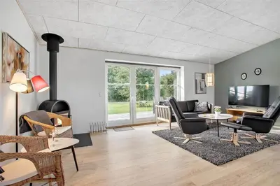 a living room with black chairs and a fireplace at JB130-Fjerritslev-Thorup-Strandvej-274 in Fjerritslev