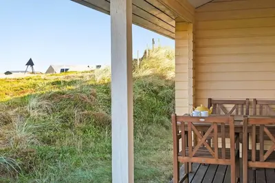 a porch with a table and a view of the beach at JB356-Frostrup-Horsbakkevej-6 in Frøstrup