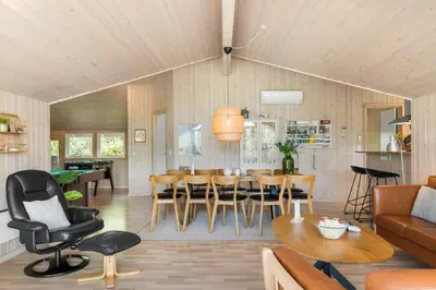 a living room with a couch and a table and chairs at JB232-Brovst-Kronvildtvej-20 in Brovst